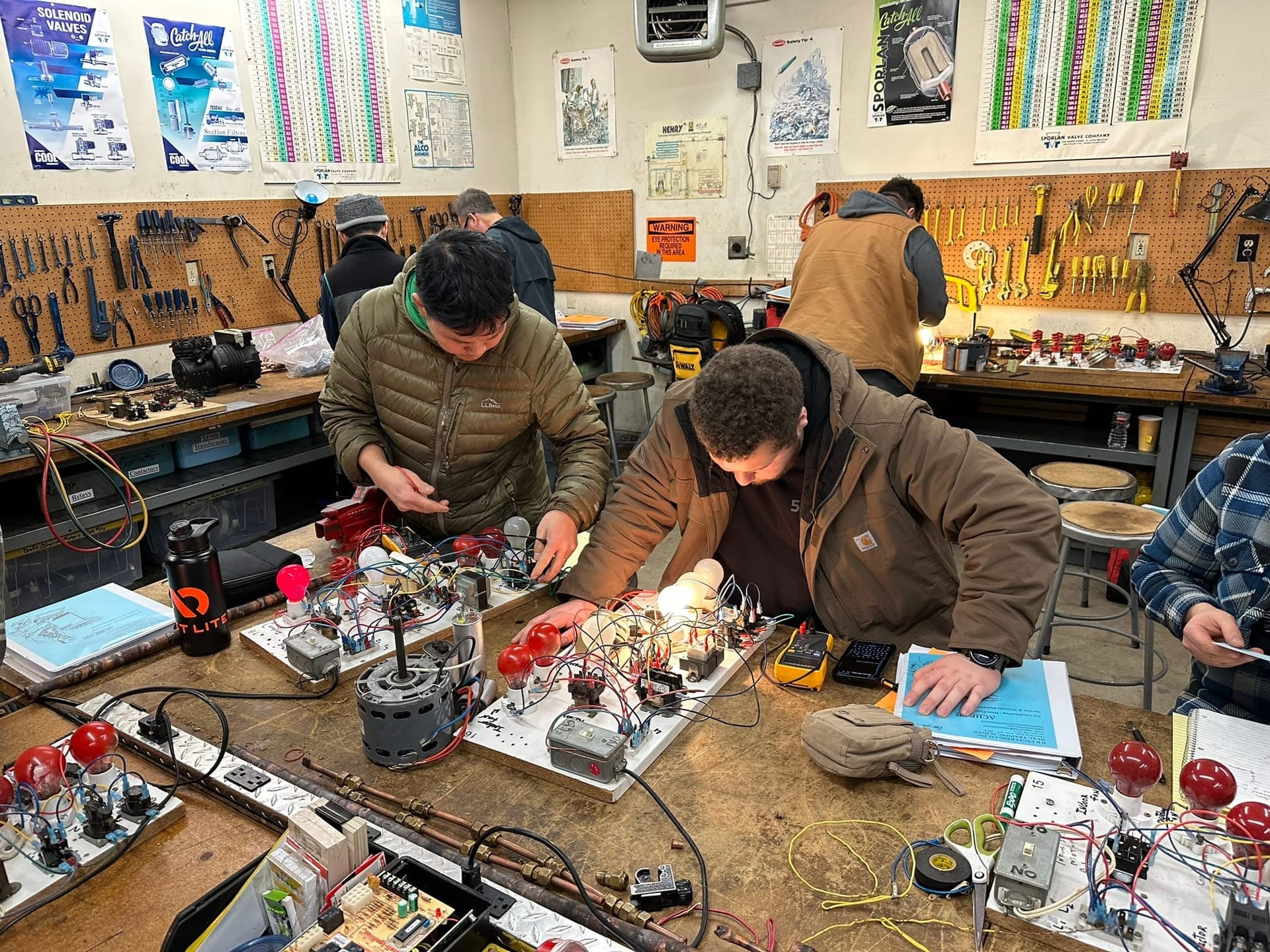 Active bench work with students, tools, and energized boards