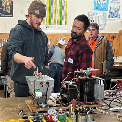 HVAC School instructor leading a small group around training equipment