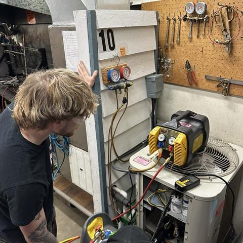 Student troubleshooting a gas furnace in the lab