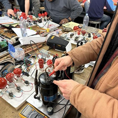 Student working through an HVAC electrical training exercise