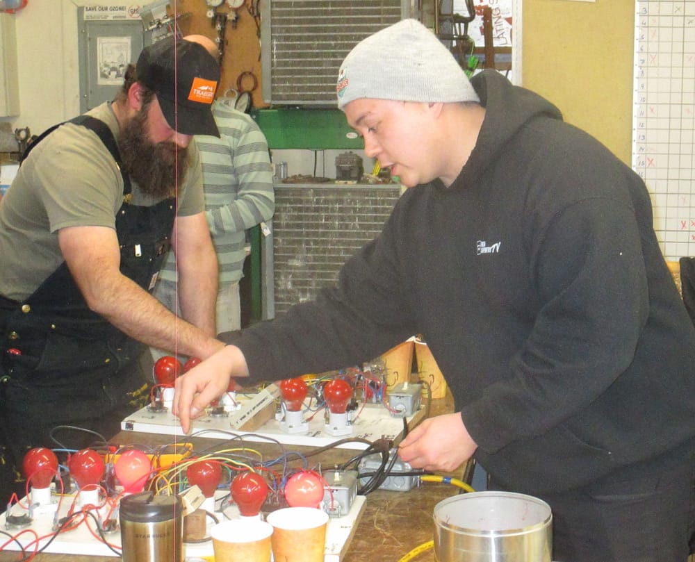 Crawford Engelking instructing at a lab electrical troubleshooting board